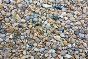 Texture of small colored pebbles on the beach