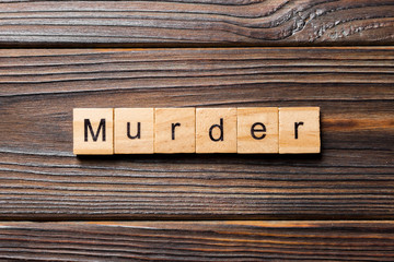murder word written on wood block. murder text on table, concept - obrazy, fototapety, plakaty