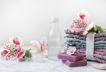 Obraz na płótnie Canvas natural soap. handmade soap with a bottle of oil. Stack of fresh towels with flowers on a white background. spa treatments. place for inscription