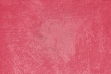 The background is a deep red painting on concrete wall with rough surface texture