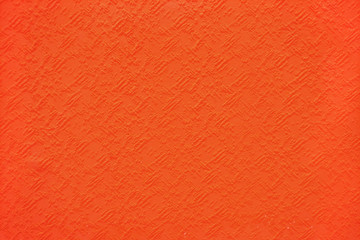 Fototapeta premium The background is a deep orange painting on stone wall with rough surface texture