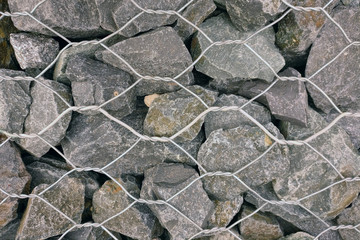 Background of strengthened gray stones with metal wire