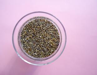 Chia seeds in bowl on pink background
