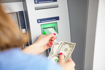 Woman using modern ATM nashine - cash withdrawal.