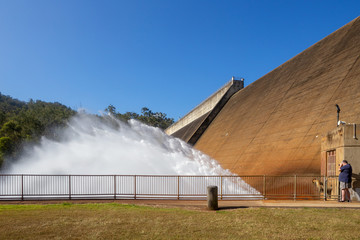 Senior man photographing water rushing from Tinaroo Falls Dam in Queenslland, Australia