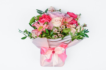 A bouquet of flowers in pink packaging on a white background. Congratulations to the women. Flowers beloved.