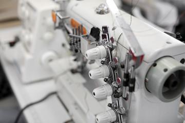 Modern sewing equipment in tailor workshop, closeup
