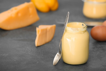 Jar of tasty sauce on grey background