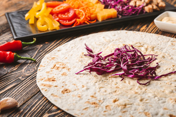 Preparing of tasty doner kebab on table