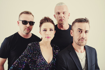 Singers, guitar player and drummer posing for music band album cover photo