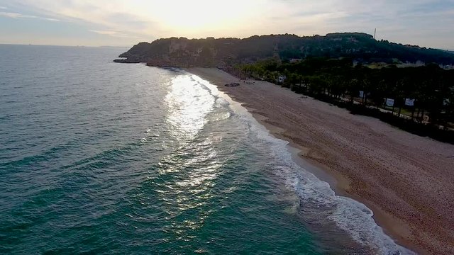 Sun reflection on mediterranean sea. Aerial view in sunset of Tamarit Beach, Tarragona, Spain
