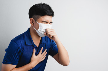 Health masked man are violent sneezing with his hands against his chest. Pollution, virus, pm 2.5, covid 19, corona virus disease prevent concept.