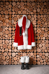 Santa Claus costume hanging on wooden wall