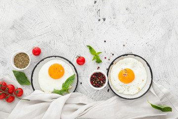 Plates with fried eggs on white background