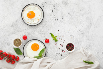 Plates with fried eggs on white background