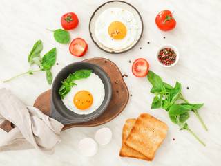 Fried eggs with toasted bread and spices on white background