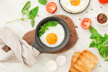 Fried eggs with toasted bread and spices on white background