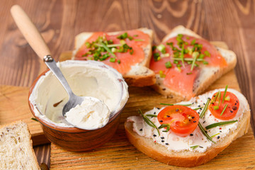 Sandwiches with tasty cream cheese on table
