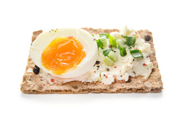 Crispbread with tasty cream cheese and egg on white background
