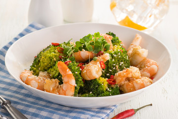 Warm salad with grilled prawns, broccoli, fresh herbs, sesame seeds and chili peppers.