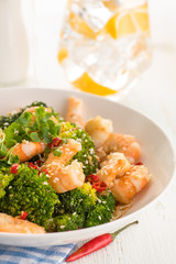 Warm salad with grilled prawns, broccoli, fresh herbs, sesame seeds and chili peppers.