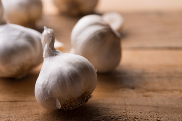 A lot of garlic on a wooden background, top view. Background for design. Horizontal photo with space