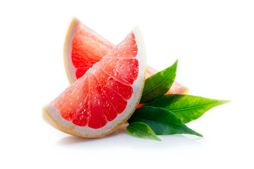 Slices of ripe and juicy grapefruit with green leaves close-up