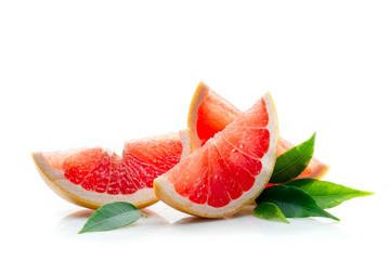 Slices of ripe and juicy grapefruit with green leaves close-up