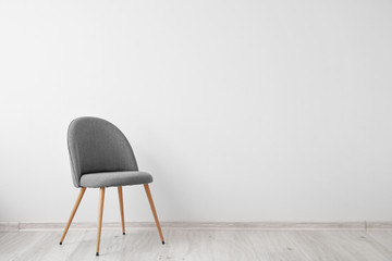 Chair near white wall in room