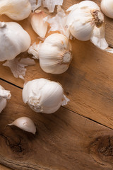 A lot of garlic on a wooden background, top view. Background for design. Vertical photo with space