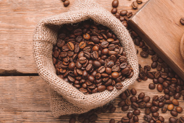 Bag with coffee beans on wooden background