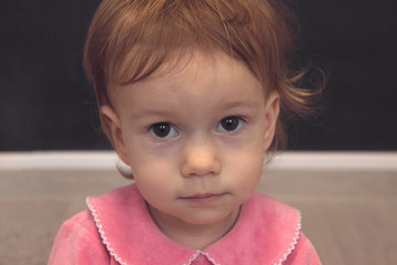 Close up little girl face with a smile and beautiful eyes looking at the camera