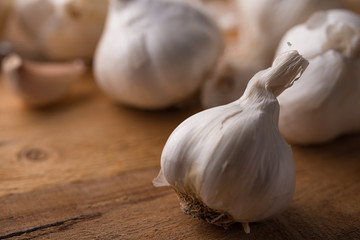A lot of garlic on a wooden background, top view. Background for design. Horizontal photo with space