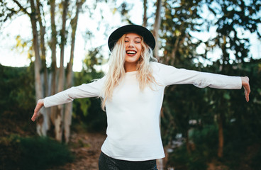 Chica muy feliz con los brazos abiertos con un sombrero negro 