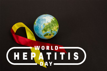 red and yellow ribbon near globe and world hepatitis day lettering on black