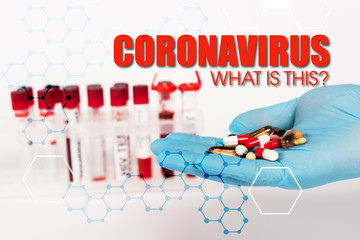 cropped view of scientist in latex glove holding pills near test tubes and coronavirus what is this lettering on white