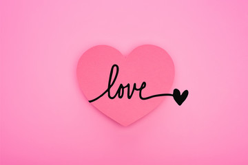 top view of paper heart with love illustration isolated on pink