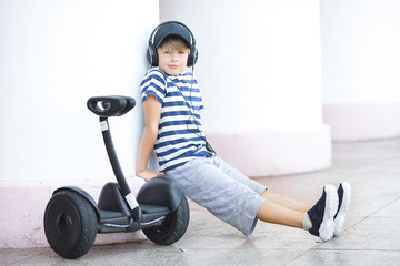 Cute child driving electric gadget. Boy riding a segway. Active child outdoors at summertime.