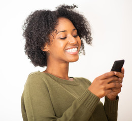 Close up smiling young african american woman using mobile phone against isolated white background