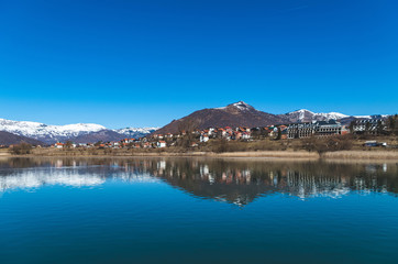 Scenic View of Lake by Mountains against Clear Blue Sky