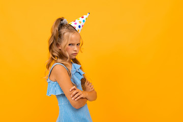 Beautiful girl with long hair has a birthday today, picture isolated on yellow background