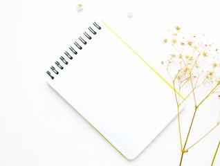 White spiral notebook with white flowers. Spring card. Top view. Copy space.