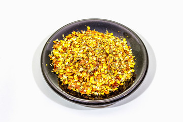 Hot seasoning in plate isolated on white background. Mix of different spices and sea salt. Traditional ingredient for cooking Italian food