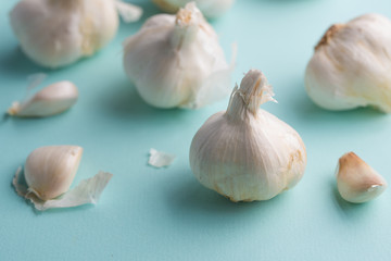 A lot of garlic on a light blue background. Close up, horizontal photo