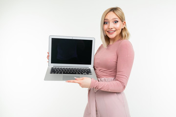 short-haired girl with white hair shows a laptop screen with an empty blank on a white studio background