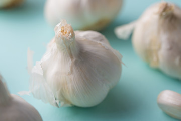 A lot of garlic on a light blue background. Close up, horizontal photo