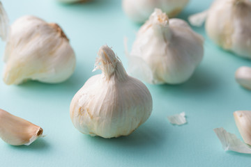 A lot of garlic on a light blue background. Close up, horizontal photo