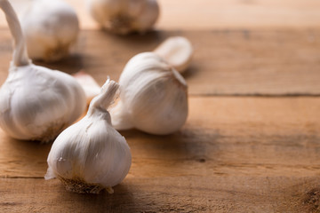 A lot of garlic on a wooden background, top view. Background for design. Horizontal photo with space