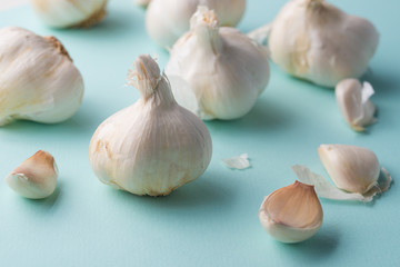 A lot of garlic on a light blue background. Close up, horizontal photo