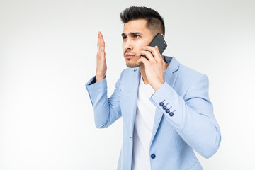 portrait of a businessman in a blue jacket talking on the phone with displeasure on important matters